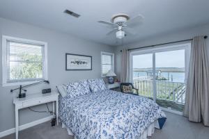 a bedroom with a bed and a desk and a window at Escape in Edisto Island