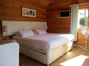 a bedroom with a bed in a room with wooden walls at Hillview Bed and Breakfast in Whitstable