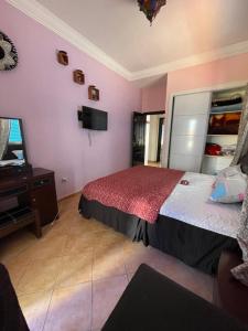 ein Schlafzimmer mit einem Bett, einem Spiegel und einem TV in der Unterkunft Luxury apartment with swimming pool view in Marina Smir