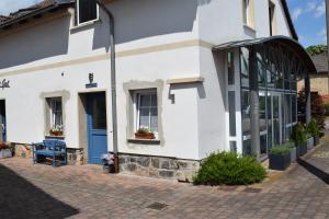 a white building with a blue door and windows at Gut Kuhfs in Großzössen