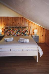 1 dormitorio con 1 cama grande y paredes de madera en Casa do Avô Horácio, en Carreço