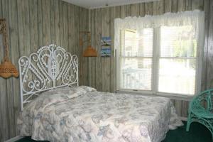 a bedroom with a white bed and a window at Jumangi in Edisto Island
