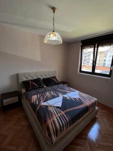 a bedroom with a bed and a chandelier at Apartment 777 in Bijelo Polje