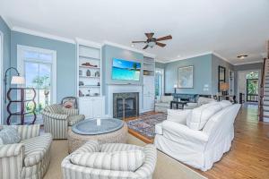 a living room with white furniture and a fireplace at Marsh Mellow in Edisto Island