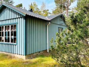 a green building with a window and a tree at 4 person holiday home in YSTAD in Ystad