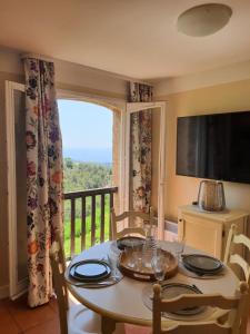 tavolo da pranzo con vista su un balcone di Appartement vue mer Golfe de Saint-Tropez a Les Issambres