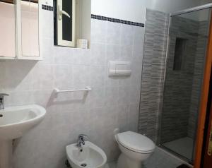 y baño con aseo, lavabo y ducha. en Villa Donà Appartamento:Defensola, en Vieste