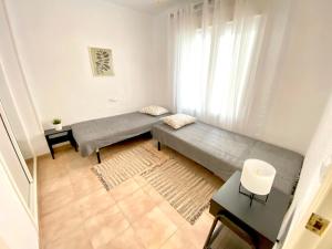ein Wohnzimmer mit einem Sofa und einem Fenster in der Unterkunft Locos Beach Holiday Apartments in Torrevieja