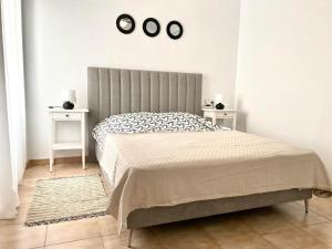 ein Schlafzimmer mit einem Bett mit zwei Tischen und zwei Uhren in der Unterkunft Locos Beach Holiday Apartments in Torrevieja