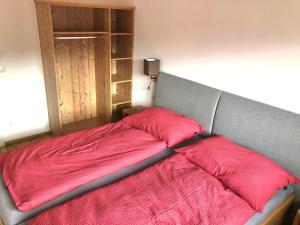 a bed with a red blanket on top of it at Appartement Grossegger in Ramsau am Dachstein