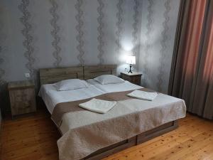 a bedroom with a bed with two pillows on it at Guest House Lake Side in Tsqaltubo