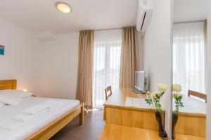a bedroom with a bed and a desk with a tv at Zimmer Katarina in Vodice