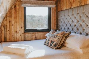 Un dormitorio con una cama grande con ventana. en Doxford Farm Camping, en Alnwick