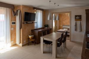 uma sala de estar com uma mesa de jantar e uma televisão em Cà da Cesare em Somendenna