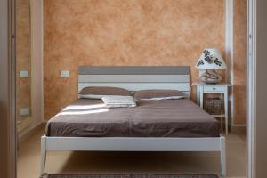 uma cama num quarto com um candeeiro sobre uma mesa em Cà da Cesare em Somendenna