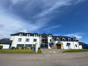 a large white building with black roof at Waterfront Lodge - Accommodation Only in Fort William
