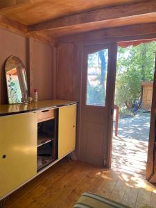 a room with a yellow cabinet and a door at Les roulottes de Bayama - logement insolite avec jacuzzi in Mougins