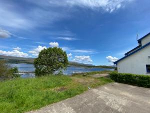 a house with a view of a body of water at Waterfront Lodge - Accommodation Only in Fort William