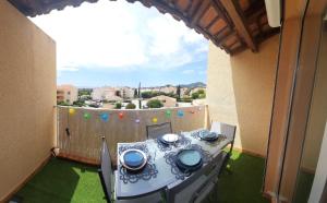 stół i krzesła na balkonie domu w obiekcie Superbe appartement avec balcon vue mer ! w mieście Carqueiranne