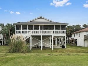 ein großes weißes Haus mit einer großen Veranda in der Unterkunft Petty House in Edisto Island