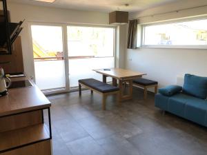 een woonkamer met een tafel en een blauwe bank bij Appartement Grossegger in Ramsau am Dachstein