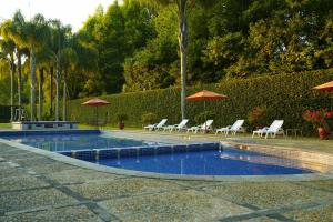 a swimming pool with lounge chairs and umbrellas at Gamma by Fiesta Americ Xalapa Nubara in Xalapa