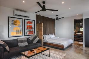 una sala de estar con una cama y un sofá en Le Suite, en Santa Teresa Beach