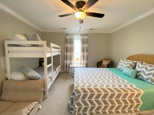 a bedroom with a bunk bed and a ceiling fan at The Pink Flamingo in Edisto Beach