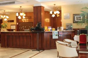 a lobby with a waiting area with a statue at a counter at Hotel Monterrey in Salamanca