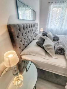 ein Schlafzimmer mit einem Bett und einem Tisch mit einer Lampe in der Unterkunft Apartments D&A in Zadar