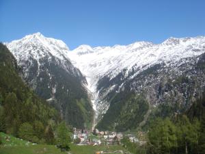 eine verschneite Bergkette mit einem Dorf in einem Tal in der Unterkunft Ferienwohnung Haus Ryter in Göschenen