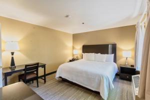 Habitación de hotel con cama, escritorio y silla en The Oakhurst Inn at Yosemite, en Oakhurst