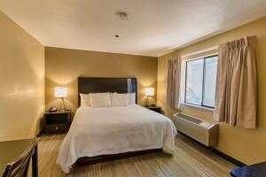 a bedroom with a large bed and a window at The Oakhurst Inn at Yosemite in Oakhurst +39 photos
