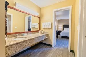 La salle de bains est pourvue d'un lavabo et d'un grand miroir. dans l'établissement The Oakhurst Inn at Yosemite, à Oakhurst