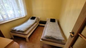 two beds in a room with a window at Domek nad stawami dla wędkarzy - Gospodarstwo Rybackie Jaworznik in Jaworznik