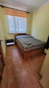 een slaapkamer met een bed, een raam en een tegelvloer bij Domek nad stawami dla wędkarzy - Gospodarstwo Rybackie Jaworznik in Jaworznik