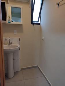 ein Bad mit einem Waschbecken und einem Fenster in der Unterkunft Studio Aconchegante no Edifício Mirante do Vale - 200Mb in São Paulo