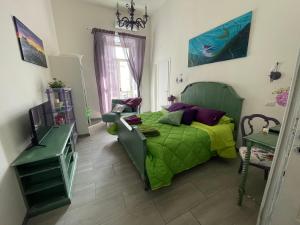 ein Schlafzimmer mit einem grünen Bett und einem Fernseher in der Unterkunft Napoli Da Vivere Suites Giudecca in Neapel