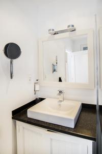 bagno con lavandino bianco e specchio di Smartflats City - Perron a Liegi