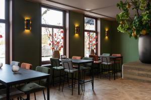 restauracja ze stołami, krzesłami i oknami w obiekcie Luxe appartementen Havenzicht w mieście Sint Annaland