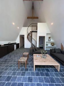 uma sala de estar com um sofá e uma mesa em La Maison Villeneuve - Lodges avec bains nordiques em Donnay