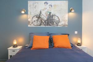 sypialnia z niebieskim łóżkiem i 2 pomarańczowymi poduszkami w obiekcie Le Rétro, T2 hypercentre chic et cosy, Wifi par SOVALFI w mieście Saint-Étienne