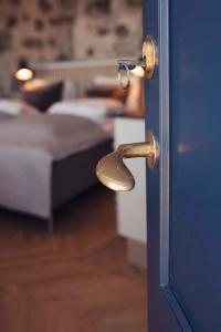 a doorhandle to a bedroom with a blue door with a bed at Dock House 95-97 in Middelfart