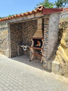 un horno de ladrillo con una mesa. en Casa Rural "A Escola" - Meãs, Pampilhosa da Serra, en Pampilhosa da Serra