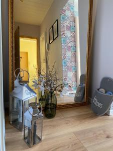 um espelho e um vaso com flores num quarto em Appartment Anna-Louise em Sondershausen
