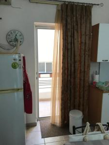 a kitchen with a refrigerator and a door with a window at Cozy Apartment Near City Center in Preveza +44 photos