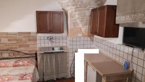 a small kitchen with brown cabinets and a sink at Monolocale ad un passo dalla chiesa del Carmine in Martina Franca