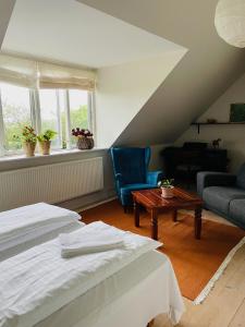 a attic room with two beds and a couch and a table at Dobbeltværelse i smuk palævilla in Stenstrup