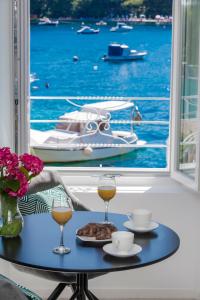 a table with two glasses of wine and a plate of food at La Porta 1, seaview apartment in the center in Cavtat