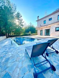 a chair sitting on a stone patio next to a swimming pool at Irinas country home! in Trimiklini